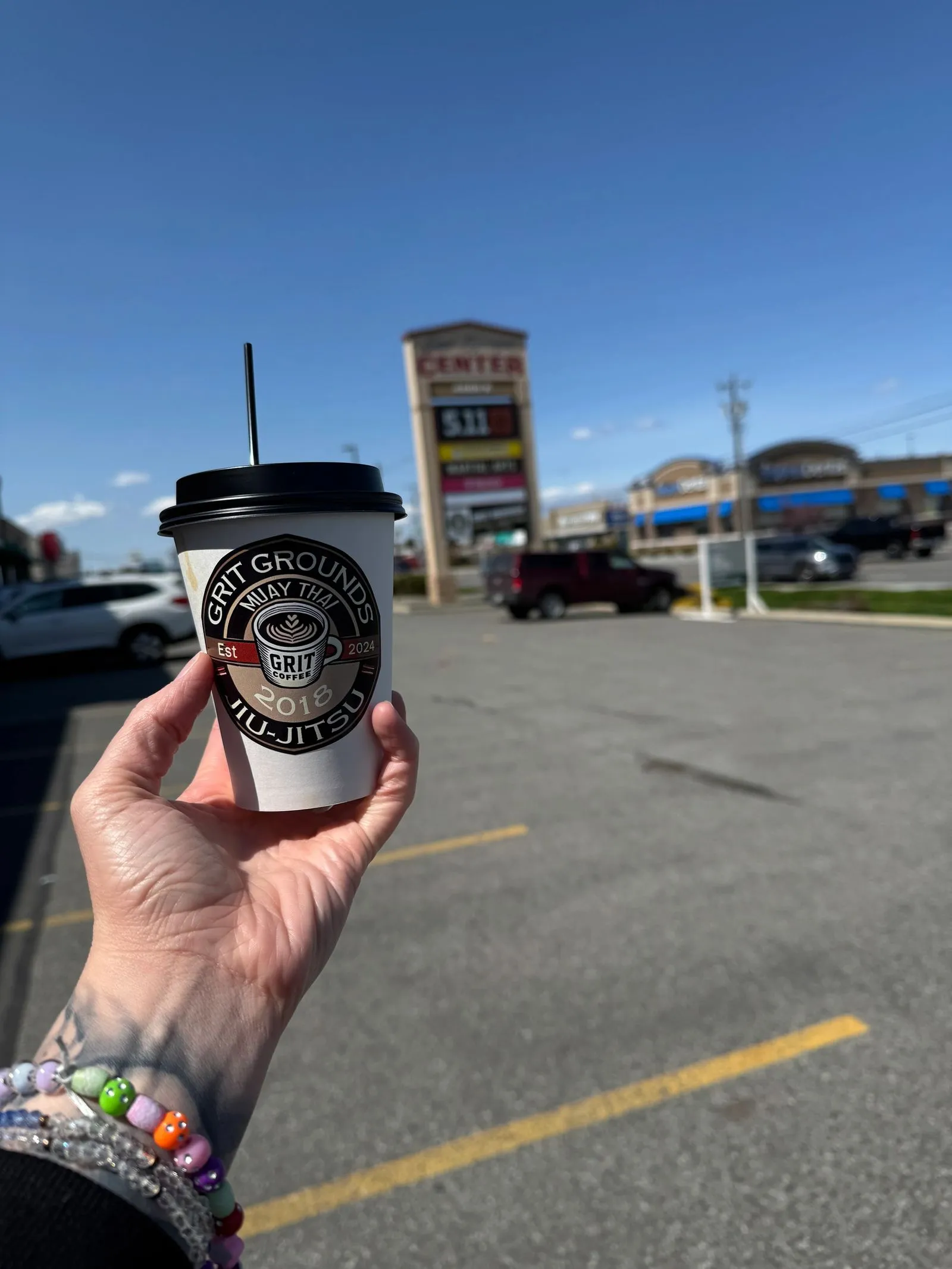 A to-go cup held up in the parking lot