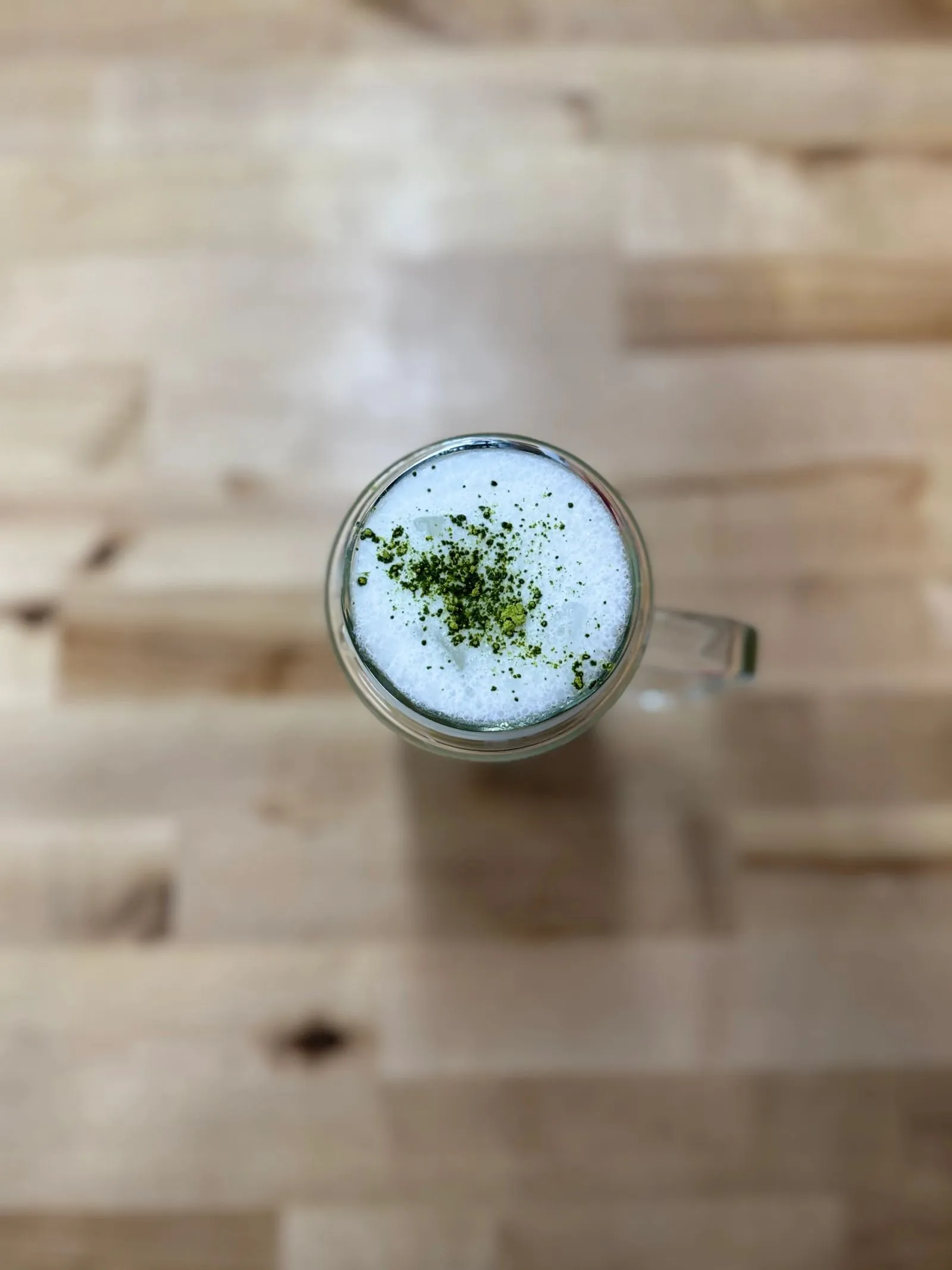 A Kimura matcha latte seen from above, dusted with matcha powder